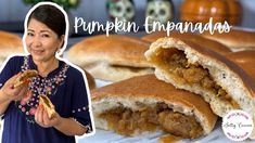 a woman holding a piece of food in front of her face and the words pumpkin enpanadas