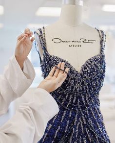 a woman is working on a blue dress