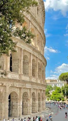 tourists walk around the roman colossion in rome, italy on a sunny day