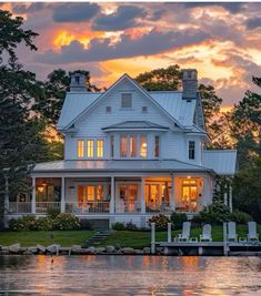 a large white house sitting on top of a lake