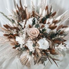 an arrangement of flowers and feathers on a white background