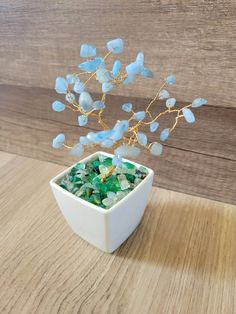 a white bowl filled with sea glass on top of a wooden table