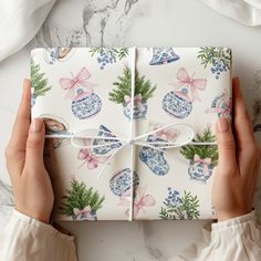 two hands holding a wrapped present on top of a marble table