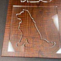 a wooden plaque with a dog cut out of it's side on top of a table