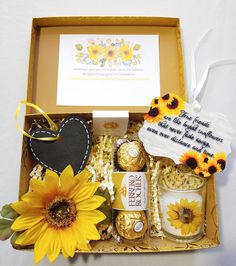 sunflowers and cookies are arranged in a gift box