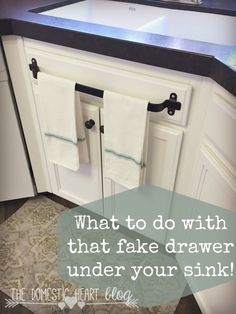 a kitchen sink with two towels hanging on it's cabinet doors and the words, what to do with that fake drawer under your sink?