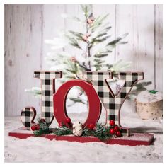 a christmas decoration with the word joy spelled out in front of a small christmas tree