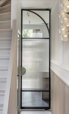 an entry way with a glass door and light fixture