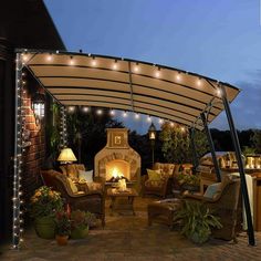 an outdoor patio covered in lights and furniture