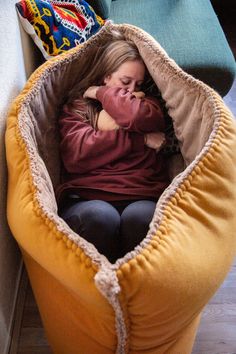 a woman is sitting in a bean bag chair with her mouth open and holding a stuffed animal