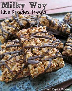 there are many pieces of rice krispies treats on the plate with chocolate drizzled on top