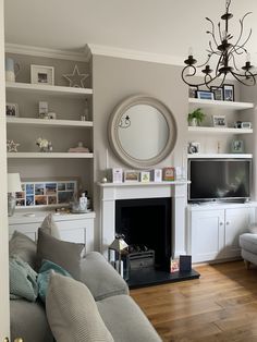 a living room filled with furniture and a flat screen tv mounted on a wall above a fire place