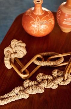 two vases and rope on a table with one knot tied to the other end