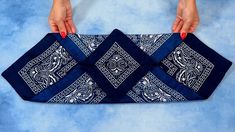 a woman's hands holding a blue and white bandana with an intricate design