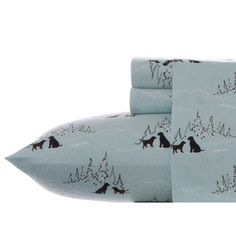 two sheets with dogs on them and snow covered trees in the background, one is blue