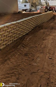 a large brick wall is being built in the dirt