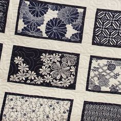 a quilted wall hanging with black and white designs