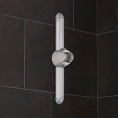 a close up of a shower handle on a tiled wall