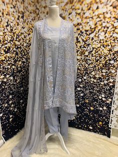 "This is elegant hi-lo, french chiffon jacket in subtle sterling silver color with sequin embroidery, paired with crepe pants, inner, and chiffon dupatta. Perfect for Eid, graduation parties, summer events, birthdays etc. Size: Medium US 8-10 Chest 38\" Waist 36\" Hips 40\" Shipping USPS 2 day" Silver Evening Sets For Festive Occasions, Silver Festive Evening Sets, Festive Silver Evening Sets, Silver Party Sets With Sheer Dupatta, Evening Party Salwar Kameez With Resham Embroidery, Semi-stitched Salwar Kameez With Dupatta For Evening, Elegant Organza Anarkali Set For Evening, Evening Salwar Kameez In Georgette With Zari Work, Festive Silver Silk Sets