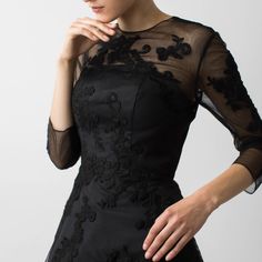 This cocktail piece is the definition of little black dress with its delicate lace applique and fit and flare skirt. The dress is fitted in the bodice with ¾ sleeves, while the crinoline underneath gives the skirt a fuller shape, emphasizing the waist.   Did we mention there are pockets? Made in Canada/ Outer 100% Polyester/ Lining 100% Polyester Crepe de Chine/ Delicate dry clean only/ Do not machine wash or tumble dry/ For a post-travel refresh, we advise using a cool iron or a gentle steam on the reverse side of any embellishment Elegant Cocktail Evening Dress With 3/4 Sleeves, Elegant Lace Cocktail Dress With Sheer Bodice, Elegant Cocktail Lace Dress With Sheer Bodice, Elegant Lace Dress With 3/4 Sleeves, Evening Lace Dress With 3/4 Sleeves, Evening Lace Dress With Sheer Fitted Bodice, Party Evening Dress With Fitted Bodice And 3/4 Sleeve, Black 3/4 Sleeve Dress For Wedding, Black 3/4 Sleeve Wedding Dress