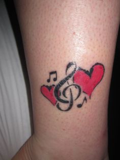 a tattoo with musical notes and hearts on it