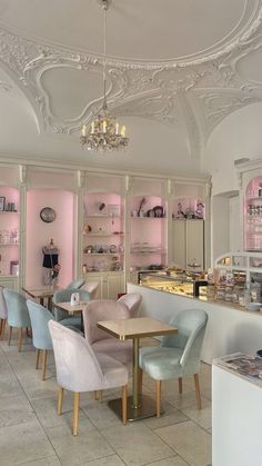 the interior of a restaurant with pastel colors and chandeliers hanging from the ceiling