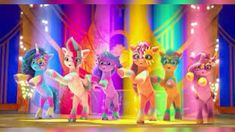 the little pony gang is standing in front of some bright colored lights and stage curtains