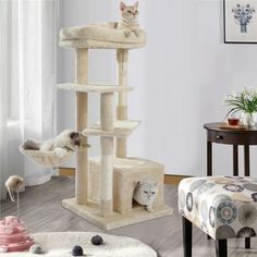 a cat tree in the middle of a living room with two cats on it's sides