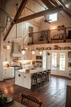 a large open concept kitchen with white cabinets and wood flooring is pictured in this image