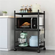 a microwave oven sitting on top of a metal shelf next to a mixer and other kitchen items