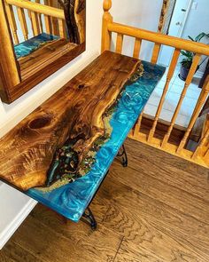 a wooden bench sitting on top of a hard wood floor next to a mirror and railing