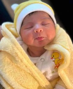 a baby wrapped up in a yellow blanket