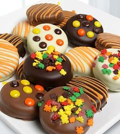 a white plate topped with lots of chocolate covered donuts and candies on top of each other