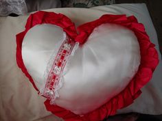 a heart shaped pillow with a measuring tape on it