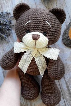 a crocheted teddy bear sitting on top of a wooden table