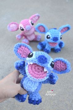 three small crocheted stuffed animals are being held by someone's hand in front of them