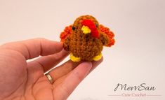 a hand holding a tiny crocheted turkey ornament