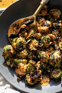 a pan filled with cooked brussel sprouts and topped with mustard sauce