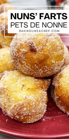 a red plate topped with donuts covered in powdered sugar