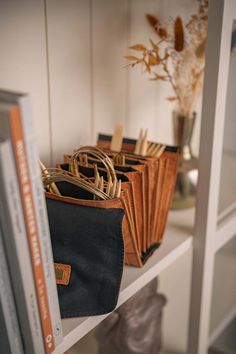 books and purses are lined up on the shelf