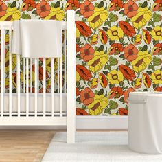 a baby crib next to a wallpaper with orange flowers