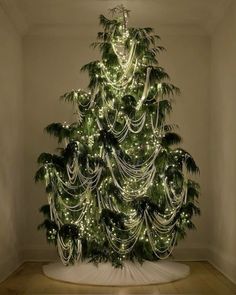 a christmas tree is decorated with lights and garlands in the shape of palm trees