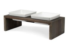 two square bowls sit on top of a wooden table with one bowl in the middle