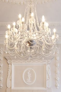 a chandelier hanging from the ceiling in a room with white walls and ceilings