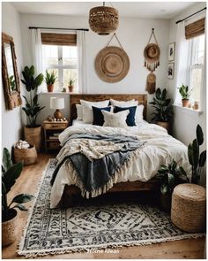 a bed room with a neatly made bed and potted plants on the side tables