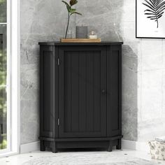 a black cabinet with a potted plant sitting on top of it next to a window