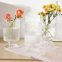 three glass vases with flowers in them on a table