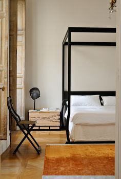 a bedroom with a four poster bed and wooden floors