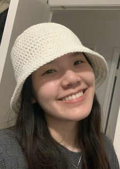 a smiling woman wearing a white crocheted hat