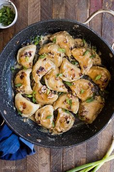 a skillet filled with cooked food on top of a wooden table